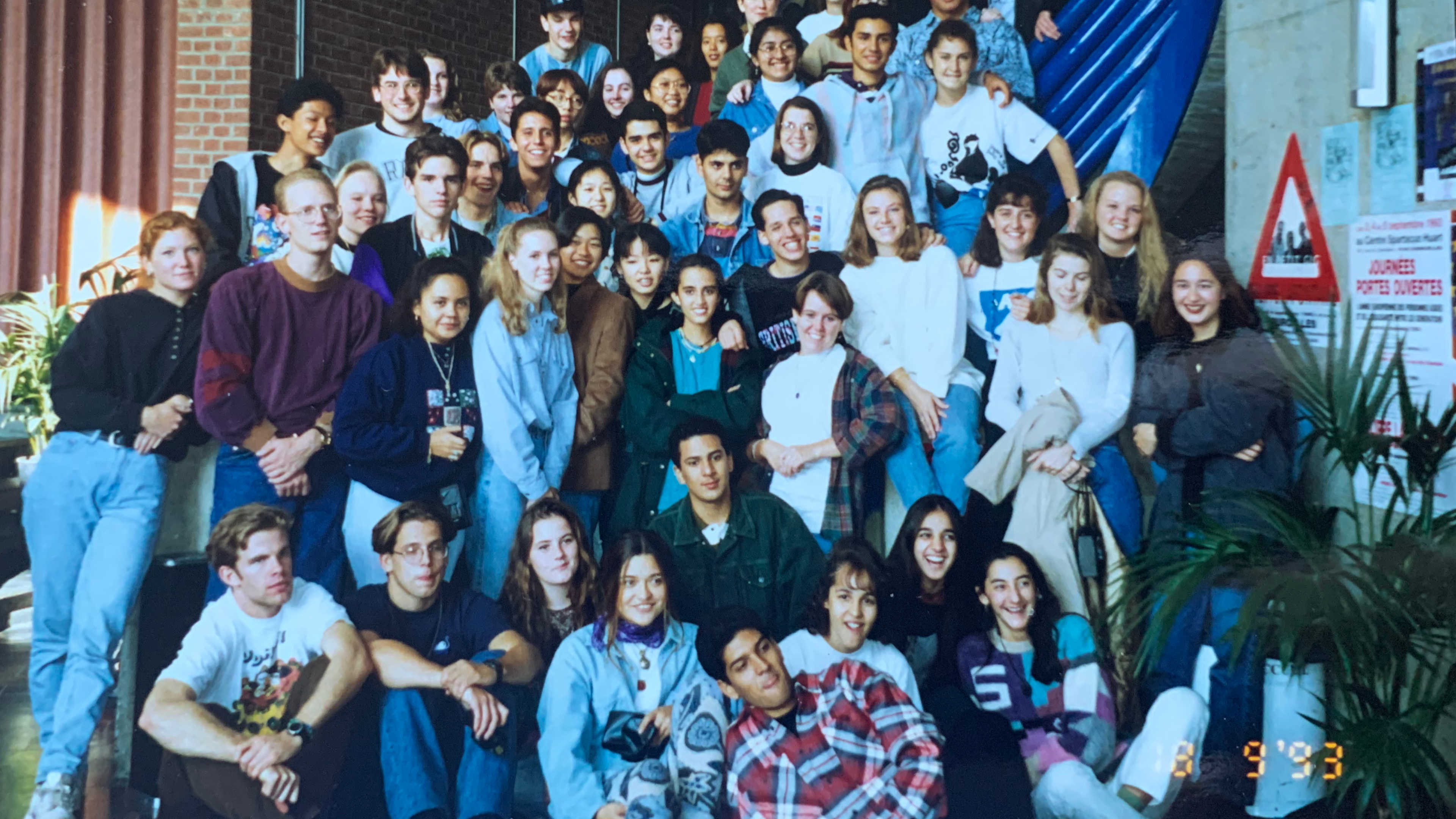 A large group of international exchange students sitting on a curved staircase